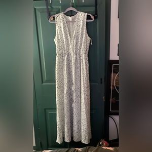 Long, sleeveless, flowy dress. White with black polka dots. Cinched at the waist